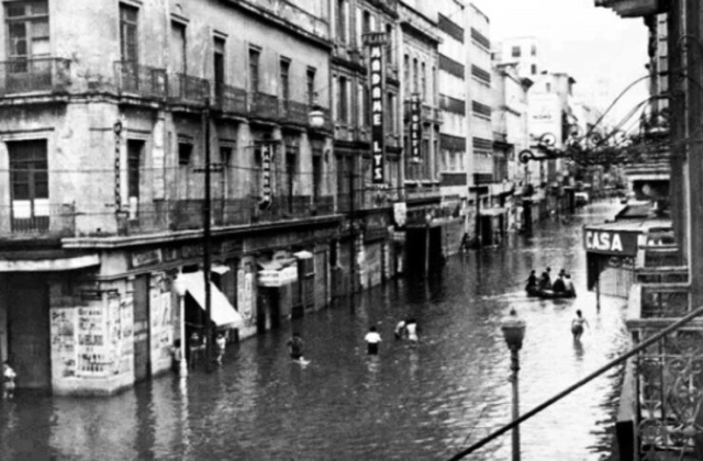 Transeúntes caminando por las calles de Ciudad de México con la inundación